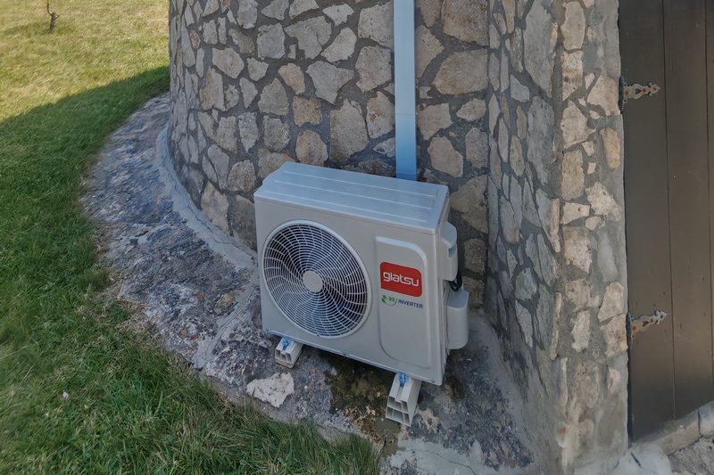Unidade exterior Giatsu instalada numa construção rústica em pedra