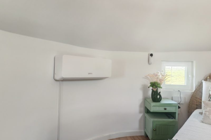 Unidade interior montada num quarto dentro da construção em pedra
