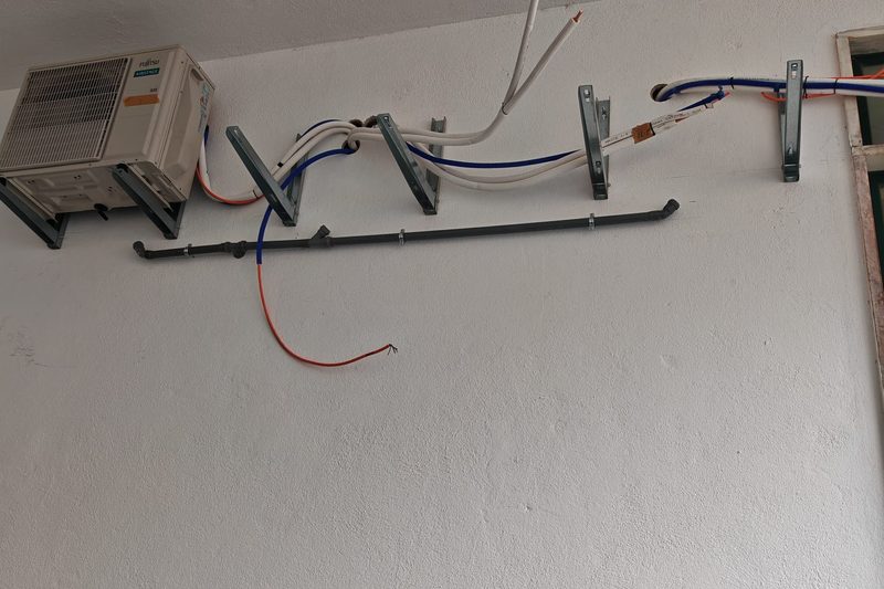 Cablagem elétrica identificada e fixada junto a uma unidade exterior