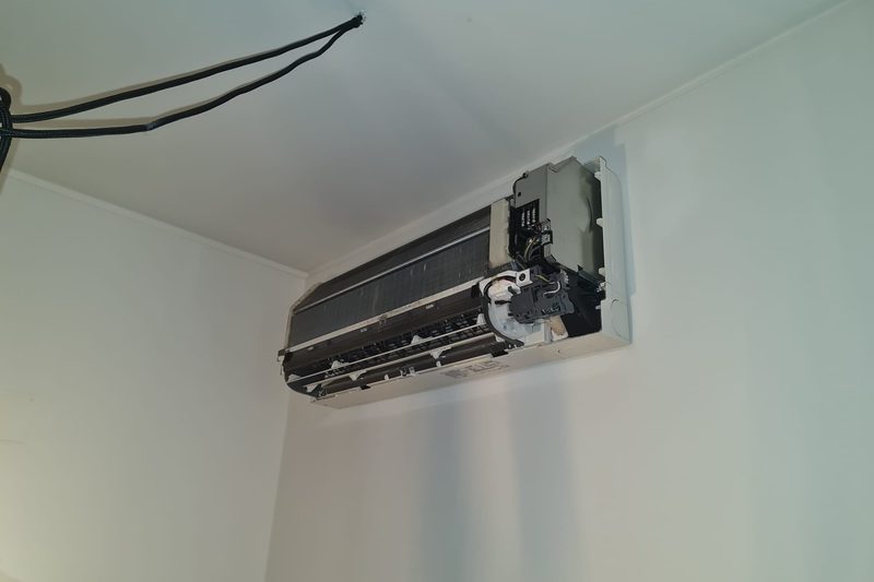 Unidade interior aberta, com placa eletrónica e cablagem visíveis durante diagnóstico