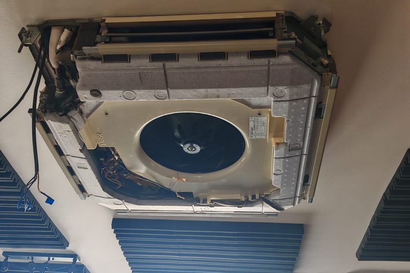 Motor e turbina de uma cassete de teto expostos durante uma intervenção de manutenção