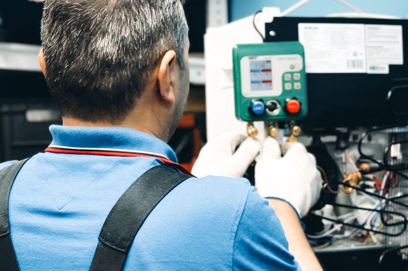 Técnico a configurar o painel de controlo de uma unidade de refrigeração comercial